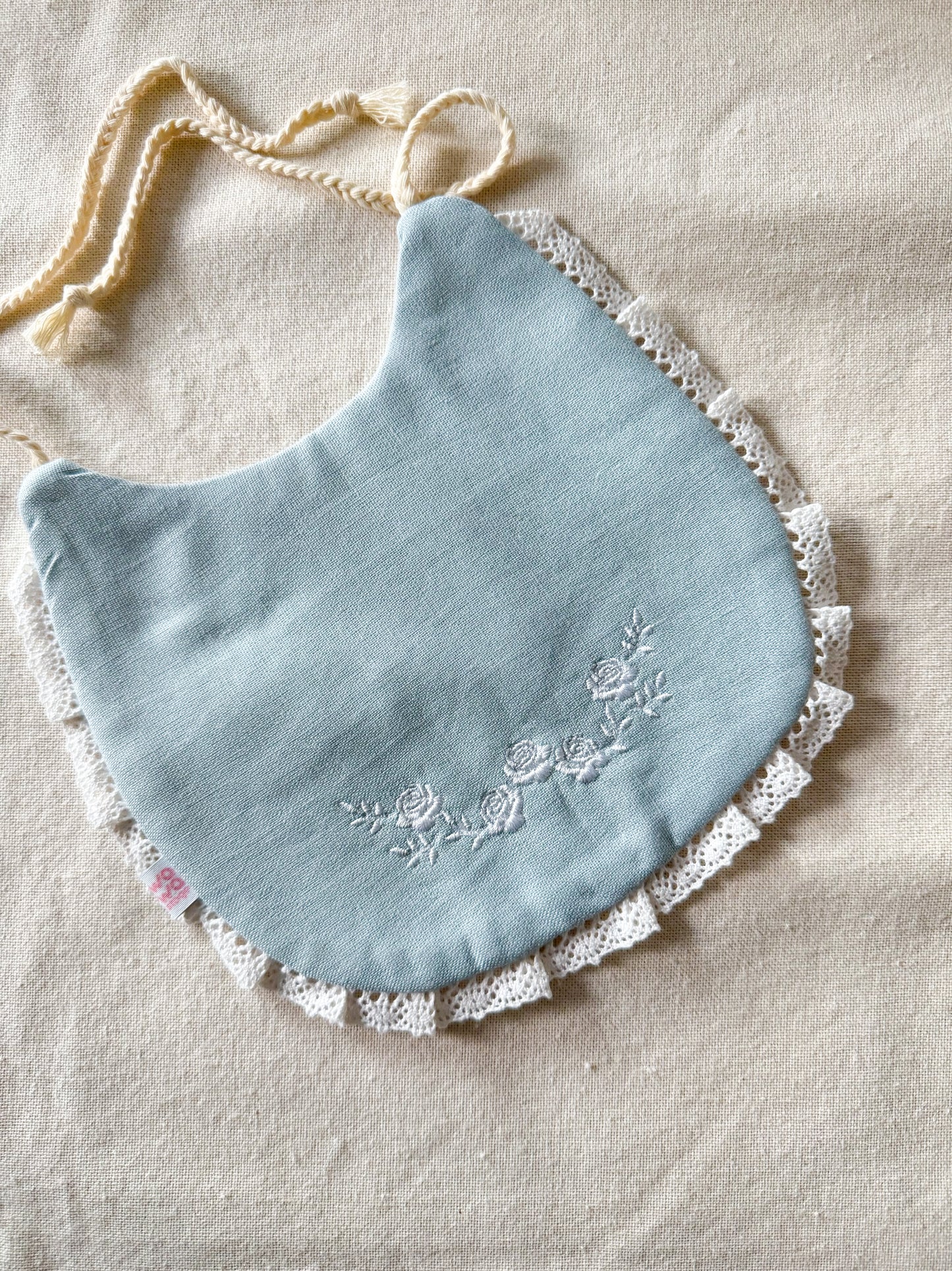 Babero bordado rositas delicadas celeste